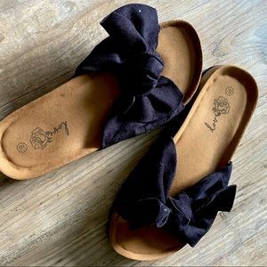 Black bow tie slip-on clogs. Brown felt cushion soles, size 8 1/2